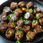 Juicy garlic butter steak bites seared in a cast iron skillet, topped with fresh parsley and glistening with rich garlic butter.