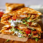 Healthy Chicken Crunch Wrap with golden tortilla, crispy chicken, lettuce, tomato, onion, cheese, and sauce