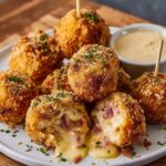Easy Chicken Cordon Bleu Bites Recipe with melted cheese and ham inside, topped with parsley and served with Dijon dipping sauce on a white plate.