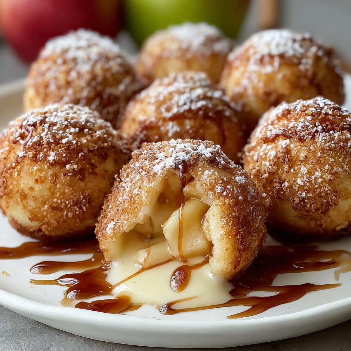 Homemade Apple Pie Bombs on a white plate, golden and sugar-dusted, one cut open showing warm caramel apple filling and cream sauce, cozy homemade feel with warm light.