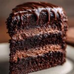 Matilda Chocolate Cake with three moist, dark layers and rich fudgy frosting, topped with a glossy chocolate drip.