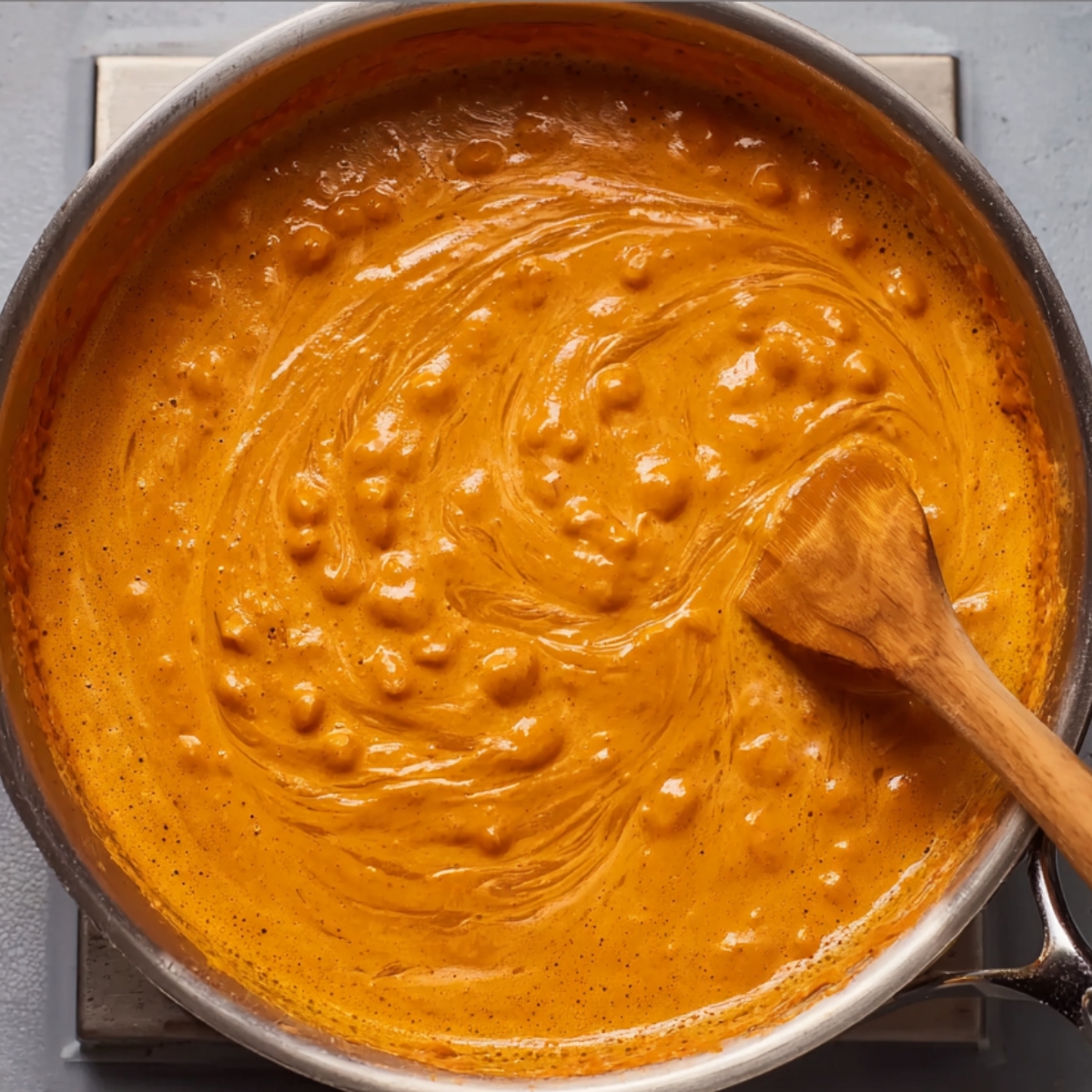 Pour in the heavy cream and oyster sauce, stirring everything together until it's smooth. Let it bubble gently for 4 to 5 minutes until it thickens slightly and turns this gorgeous peachy-coral color.