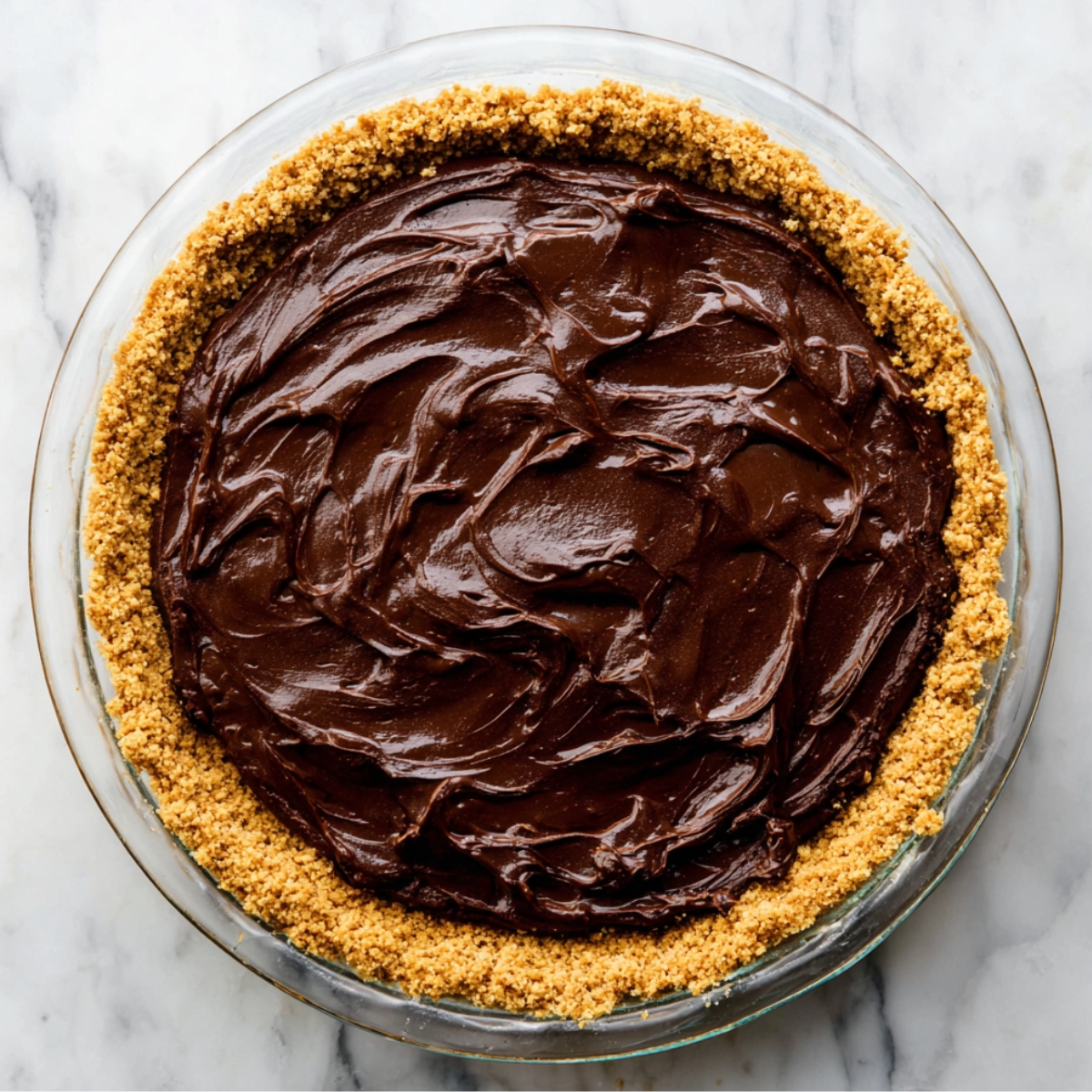 Gently fold the chocolate chips into the thick batter using a spatula. Immediately spoon this batter into your prepared graham cracker crust and spread it evenly.