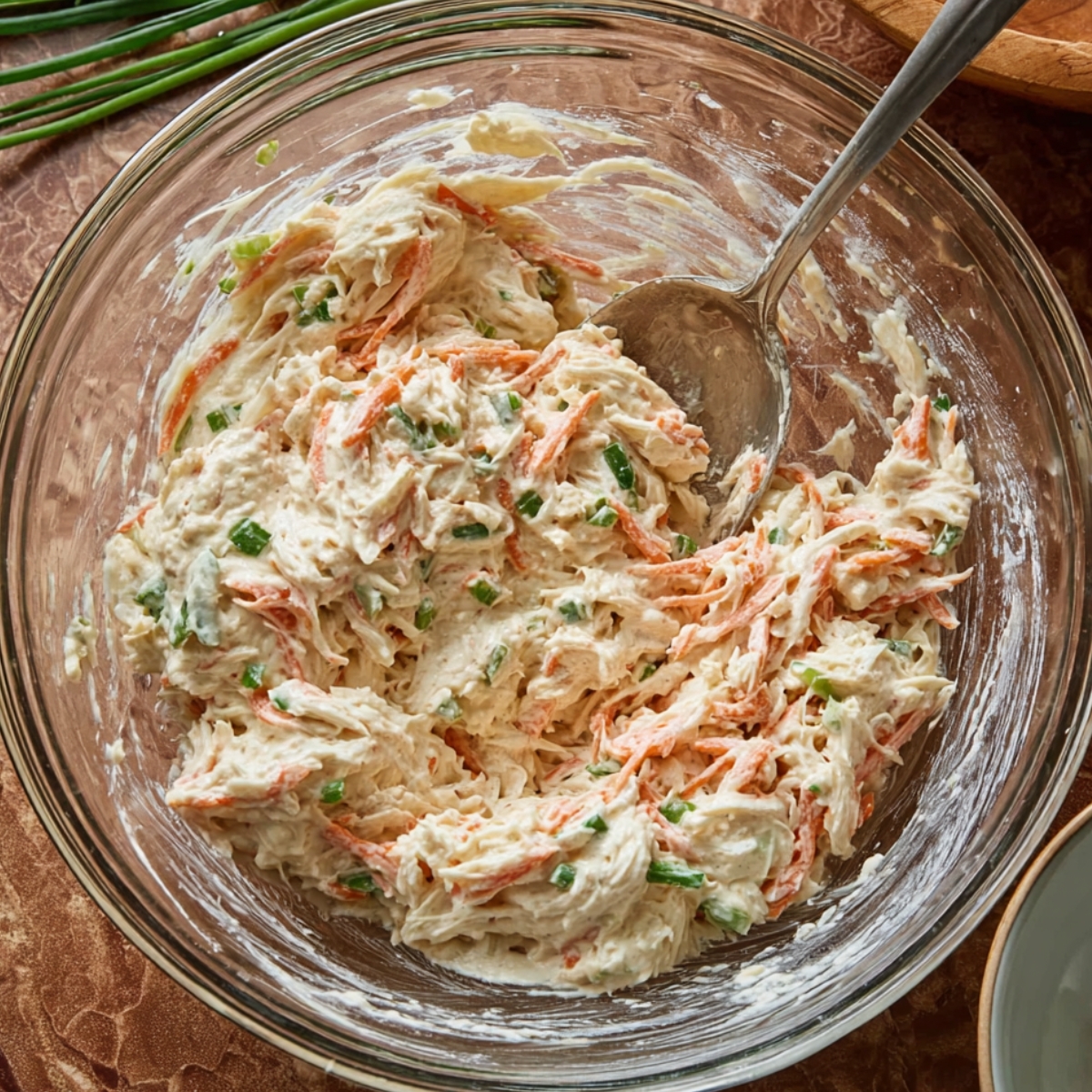 In a large mixing bowl, combine the chopped imitation crab meat, softened cream cheese, finely chopped green onion, soy sauce, Worcestershire sauce, garlic powder, sugar, and black pepper. Use a fork to mash and mix everything together until it's well blended and creamy, about 1 to 2 minutes.