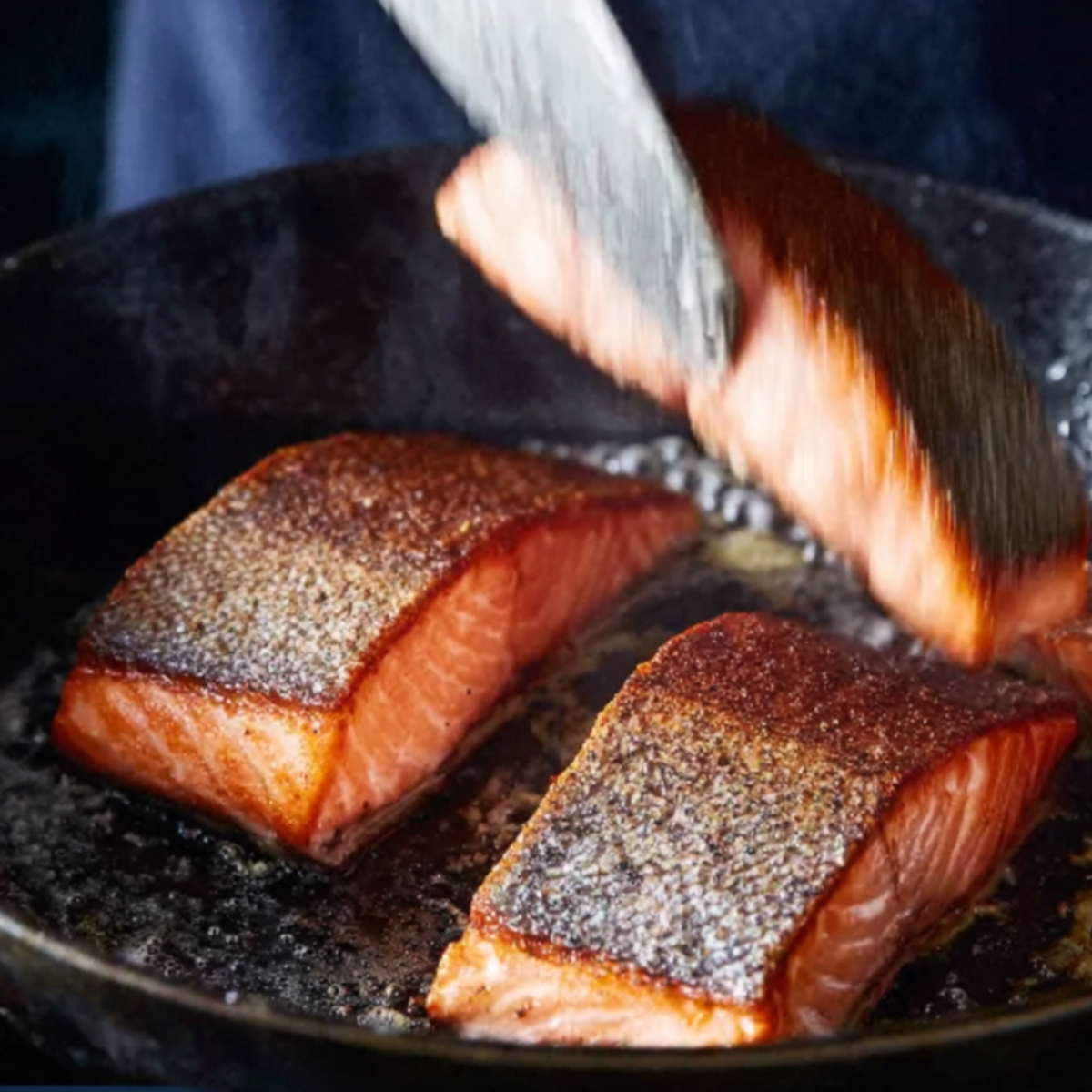 Upside-down salmon fillets in a hot pan.