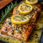 Cooked Garlic Butter Salmon fillets with crispy skin, topped with lemon slices and garlic butter.