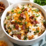 A close-up of the prepared Bacon Ranch Chicken Salad with shredded chicken, cheddar cheese, crispy bacon, and green onions.